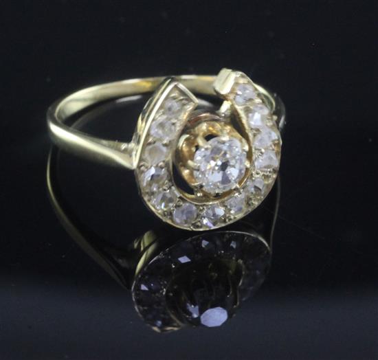 A gold and diamond set horseshoe shaped ring, size L.